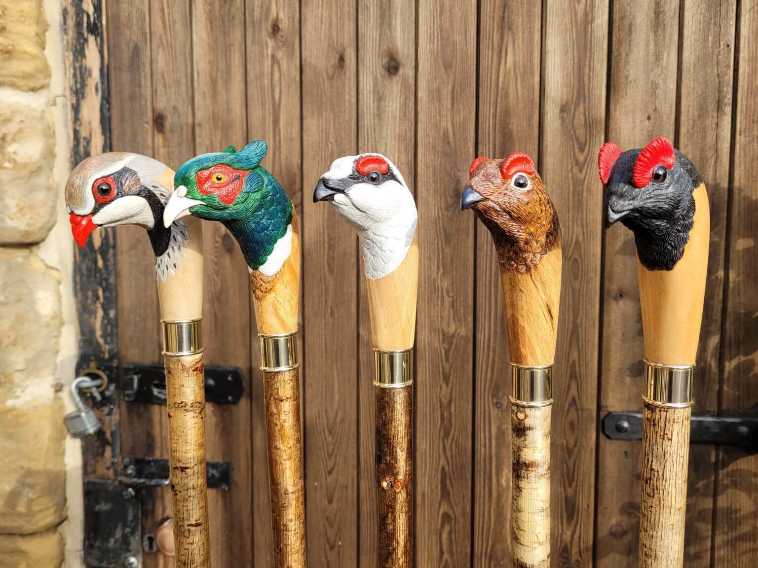 Five hand-carved game bird walking sticks, with detailed painted heads and brass collars